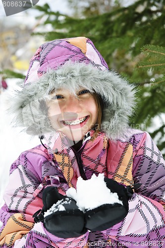 Image of Happy winter girl holding snow