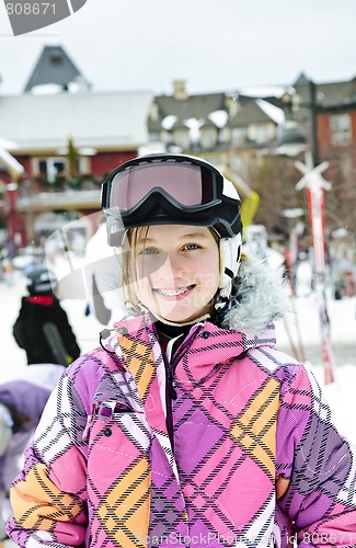 Image of Happy girl in ski helmet at winter resort