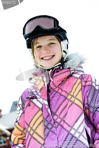 Image of Happy girl in ski helmet at winter resort
