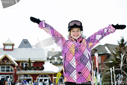 Image of Happy girl with arms raised at resort