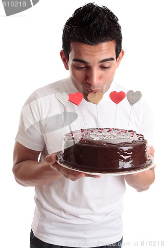 Image of Romantic man kissing heart on a cake