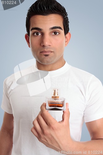 Image of A man holds a bottle of cologne