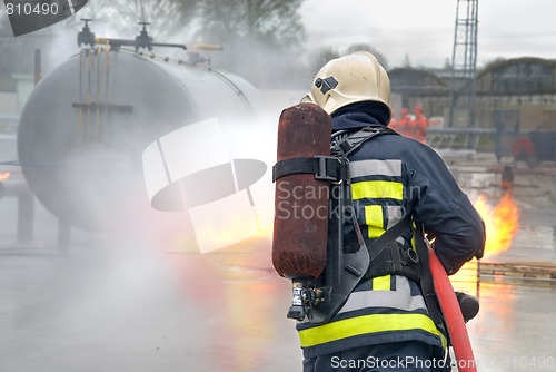 Image of Firefighter extinguishing tank fire