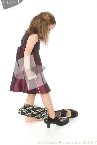 Image of little girl trying moms shoes