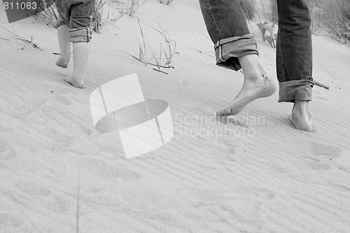 Image of running father and kid - toes in sand