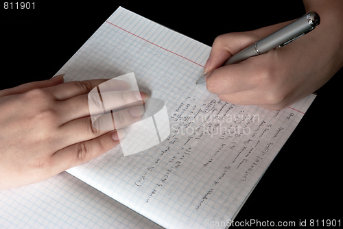 Image of woman writing in a school notebook