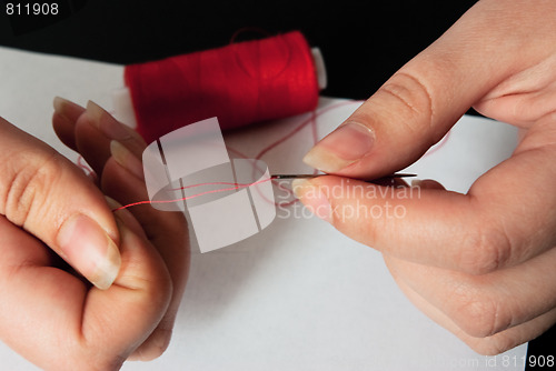 Image of woman threading a needle