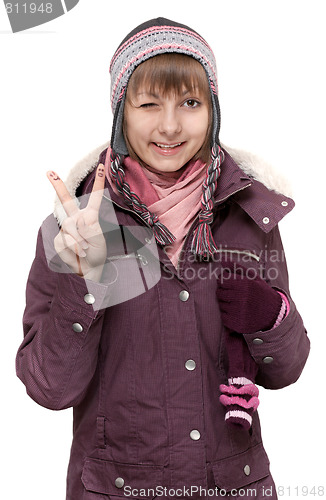 Image of Young beautiful girl in winter to jacket and hat shows Ok