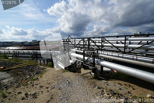 Image of industrial pipelines on pipe-bridge against blue sky