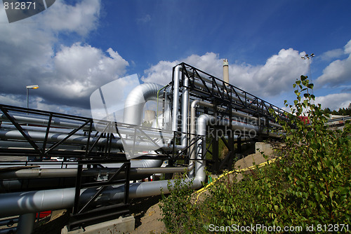 Image of industrial pipelines on pipe-bridge against blue sky