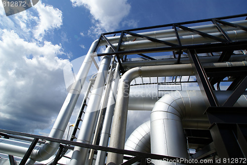 Image of industrial pipelines on pipe-bridge against blue sky