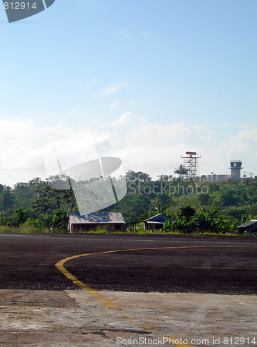 Image of airport tarmac runway with houses in jungle