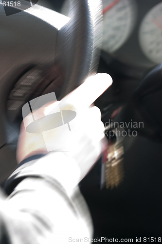 Image of Abstract Blurry Hand on Steering Wheel