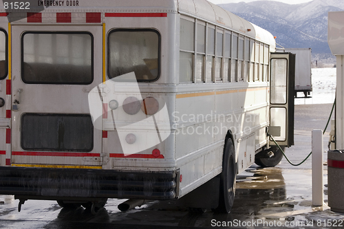 Image of White School Bus Pumping Gas