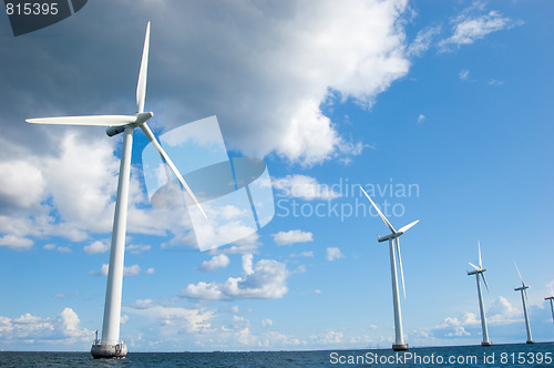 Image of Four windmills in a row on sunny day