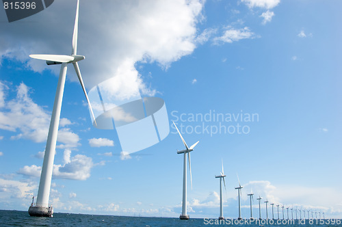 Image of Windmills lined up in the sea, close