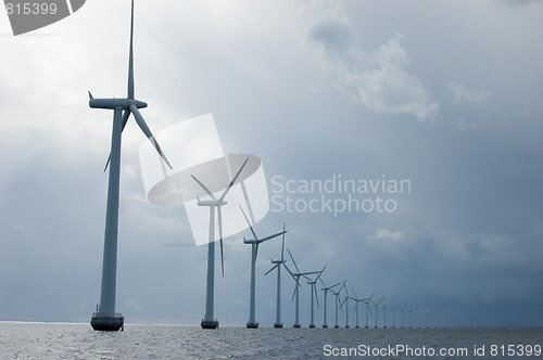 Image of Windmills in a row on cloudy weather, close