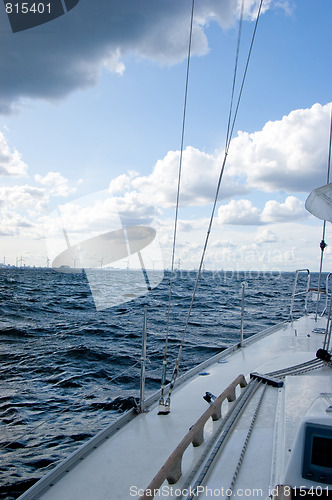 Image of Sailing boat and windmills on sunny day, vertical