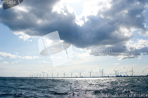 Image of Clouds on blue sky over windmill farm