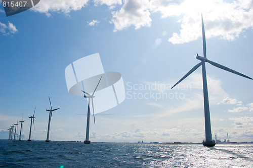 Image of Windmills in a row on sunny day, close,