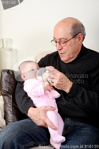 Image of Grandpa bottle feeding baby girl