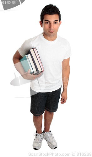 Image of Male college student standing with textbooks under one arm