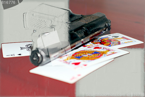 Image of abstract gun and playing cards on table in casino
