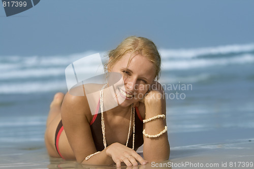 Image of good looking woman rolling around in the surf