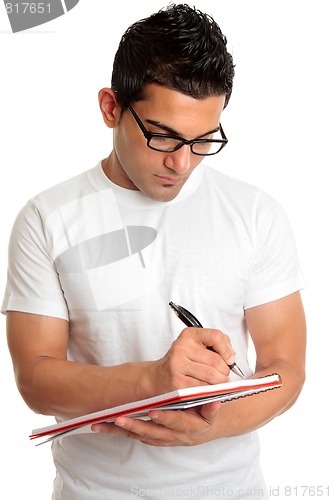 Image of Student in glasses writes in book