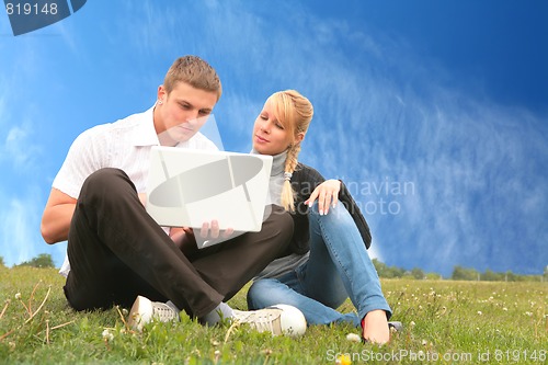 Image of young man and girl blonde with laptop