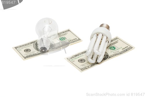 Image of Energy save lamp versus bulb on dollar bills isolated
