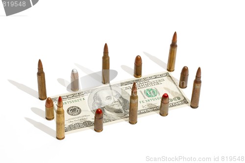 Image of One hundred dollar bill fenced by cartridges isolated 