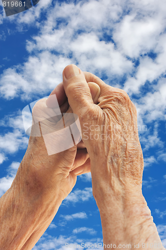 Image of Senior woman's hands over sky