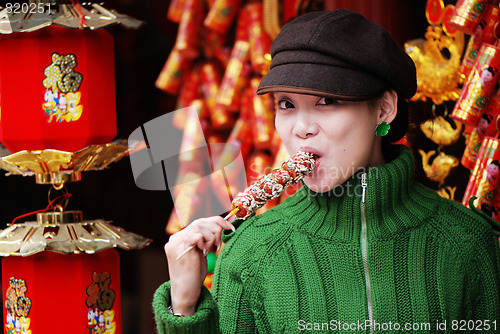 Image of China girl eating candied fruit