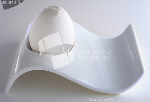 Image of White egg in eggcup with cracked top