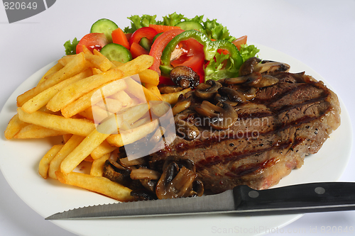 Image of Ribeye steak dinner with knife