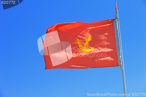 Image of anchor on red flag blue sky