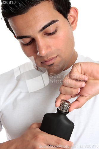 Image of Guy removes lid from aftershave bottle