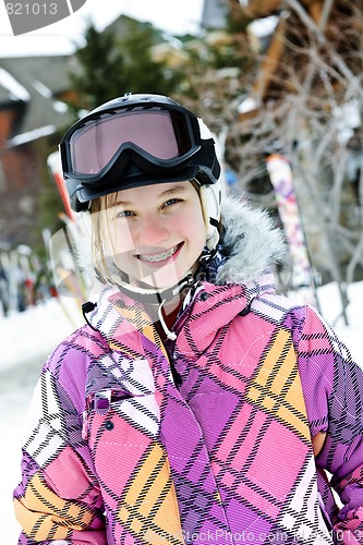 Image of Happy girl in ski helmet at winter resort