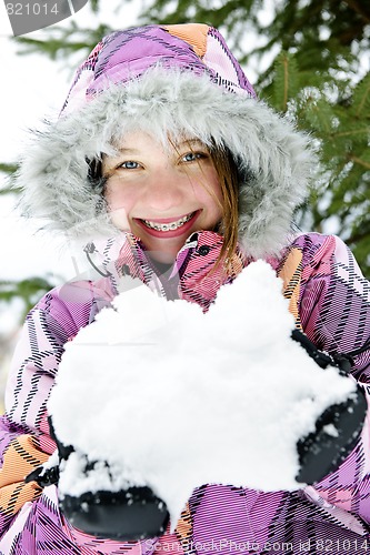 Image of Happy winter girl holding snow