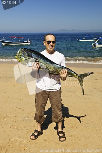 Image of Tourist holding big fish on beach