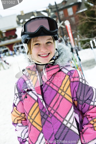 Image of Happy girl in ski helmet at winter resort