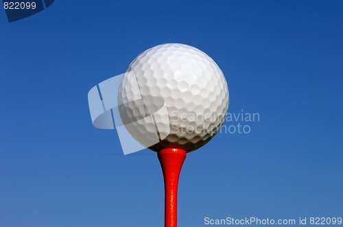 Image of White Golf Ball on Red Tee