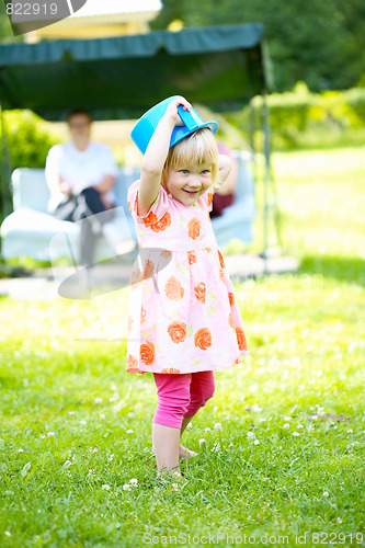 Image of Little girl playing outdoors in summer