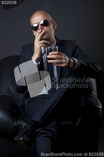 Image of businessman smoking and drinking