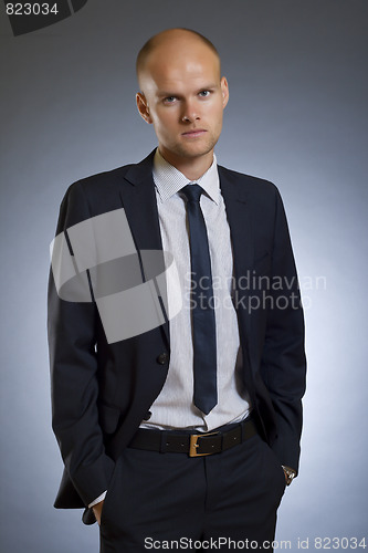 Image of businessman standing with hands in pockets