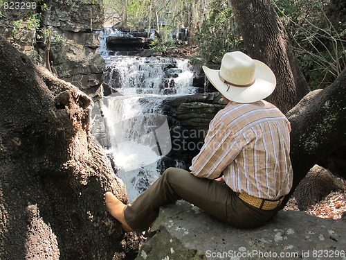 Image of Cowboy by waterfall