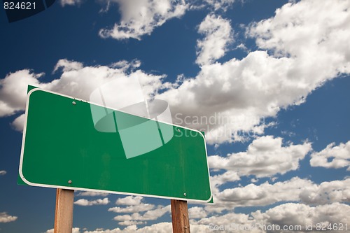 Image of Blank Green Road Sign Over Clouds with Text Room