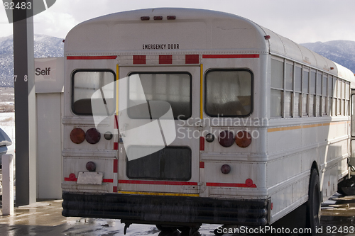 Image of White School Bus Pumping Gas