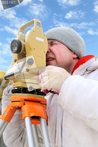 Image of land surveyor workers using theodolite equipment at construction